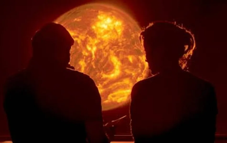 Två personer som sitter framför en döende sol