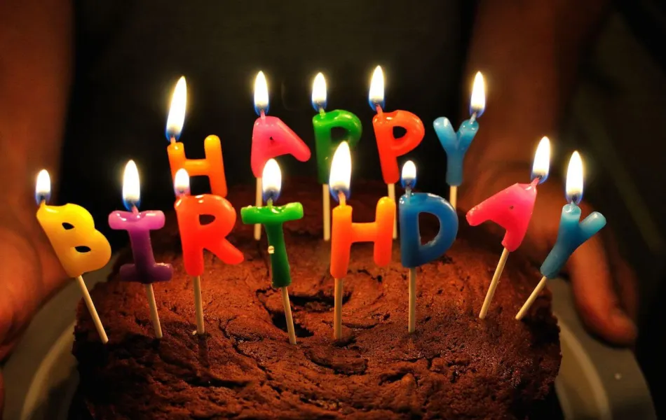 Tårta med ljus i form av bokstäver som bilder Happy Birthday