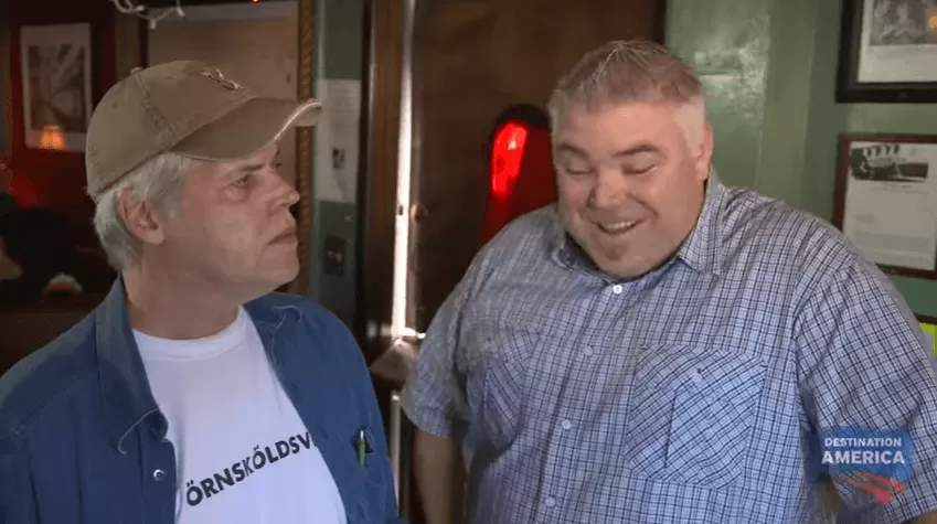 Två herrar varav en av en vit t-shirt med texten "Örnsköldsvik"